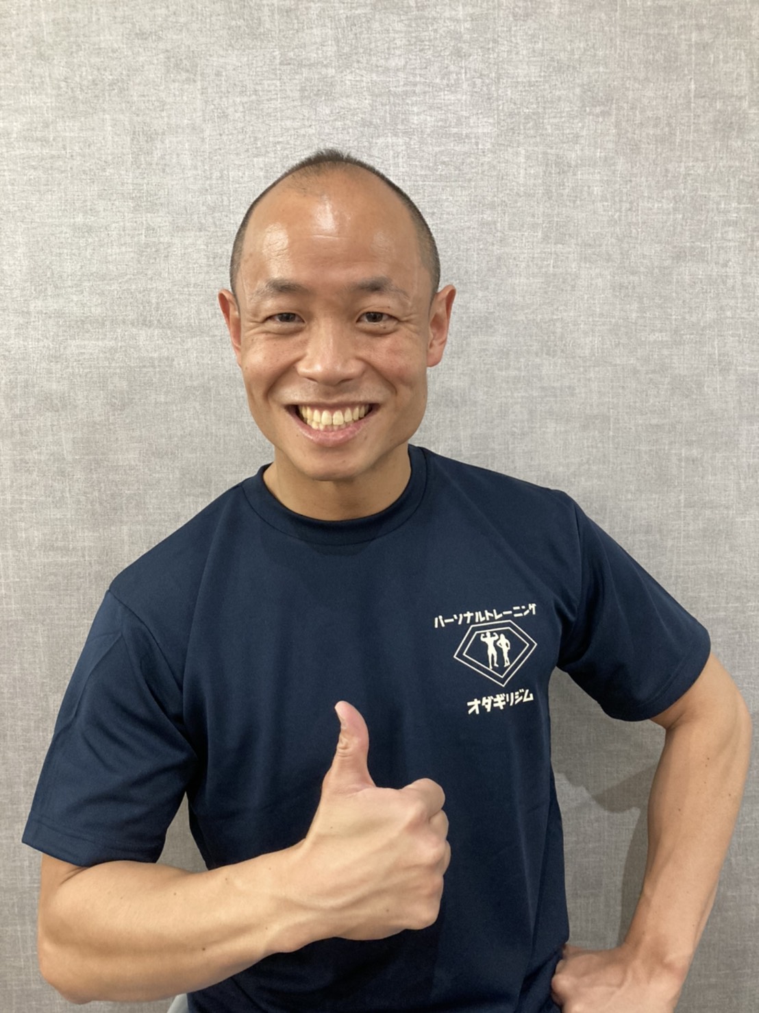笑顔で親指を立てる小田切雄太トレーナー